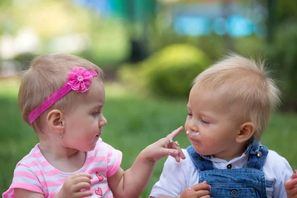 Niños pequeños comiendo pastel juntos, golpeándose a sí mismos — Foto de Stock