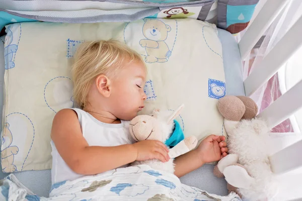 Милый мальчик в повседневной одежде, спит в постели с Тедди Би — стоковое фото