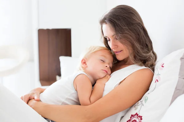 Junge Mutter liegt mit ihrem schlafenden Kleinkind im Bett — Stockfoto