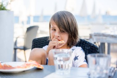 Sevimli okul öncesi çocuk, restoranda oturan, outdo pizza yemek