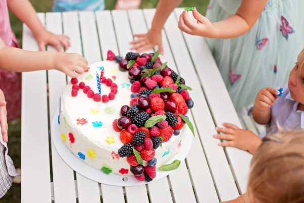 Małe dzieci ręce, jedzenie owoców z ciasta Birhtday — Zdjęcie stockowe