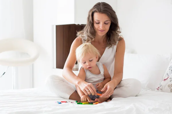 Moeder speelt met haar peuter jongen in de slaapkamer met magnetische Woode — Stockfoto