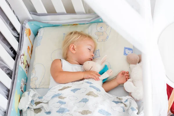 캐주얼 한 옷을 입은 달콤한 아기 소년, 침대에서 테디 비와 함께 자고 — 스톡 사진