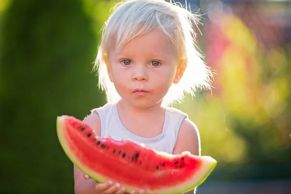 Cute toddler child, baby boy, eating ripe watermelon in garden — Stock Photo, Image