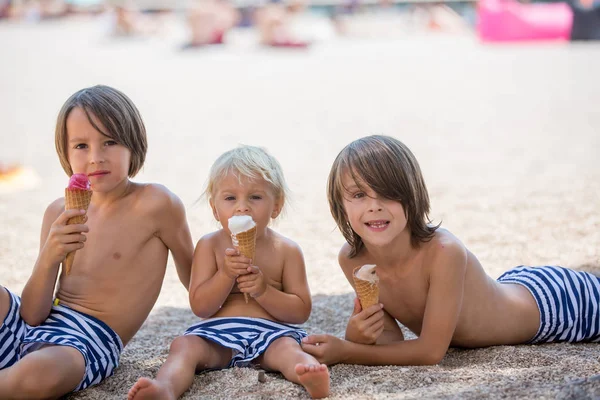 Dolce bionda bambino ragazzo e il suo per i fratelli maggiori, mangiare ghiaccio — Foto Stock