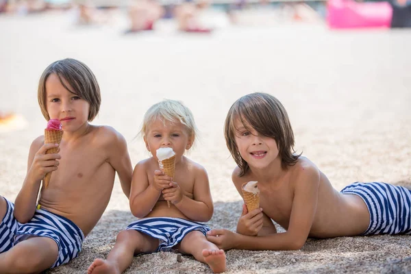 Dulce rubia niño y su a los hermanos mayores, eaiting hielo — Foto de Stock