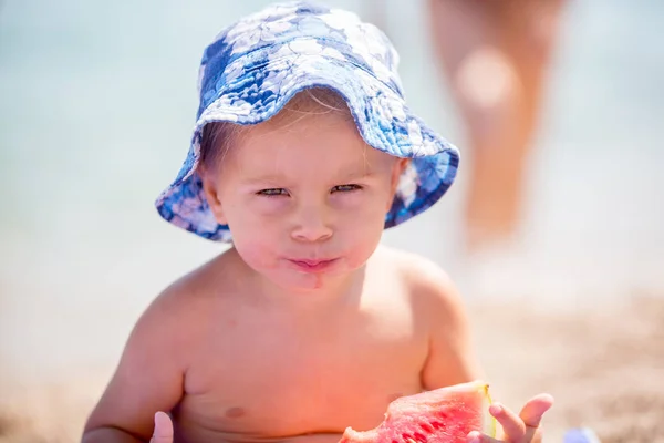 Lindo niño, niño rubio, comer sandía en la playa co — Foto de Stock