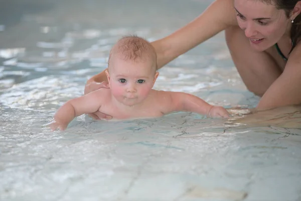 Pequeño bebé lindo, nadando felizmente en una piscina poco profunda —  Fotos de Stock