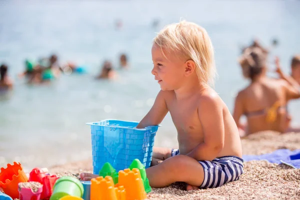 Mooie twee jaar oude peuter kind, jongen, spelen met strand t — Stockfoto