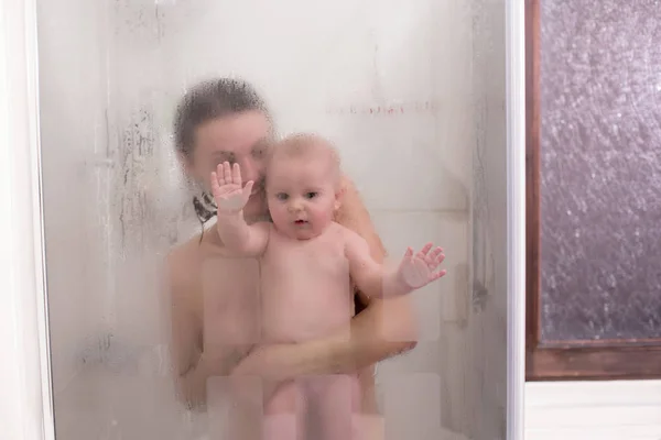 Mãe e menino no chuveiro, gotas de água — Fotografia de Stock