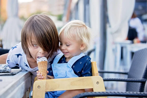 Kicsi édes kisgyermek fiú, étkezési fagylalt-ból egy kúp, ülő — Stock Fotó