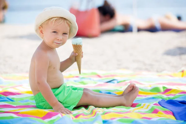 Dolce ragazzo bambino biondo, mangiare gelato sulla spiaggia — Foto Stock