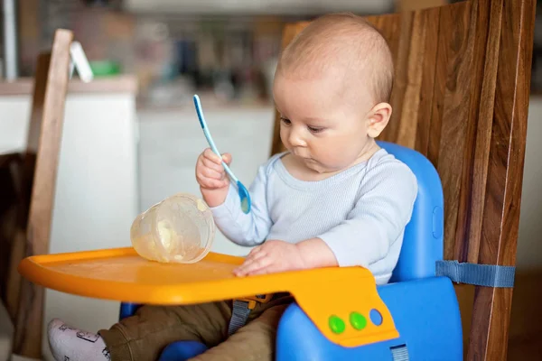 Pequeño niño, comiendo puré de alimentos por primera vez —  Fotos de Stock