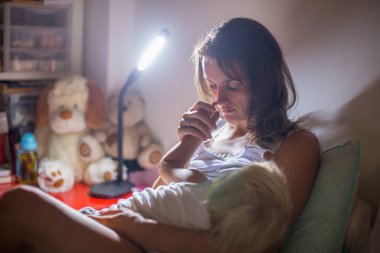 Anne, gece evde onu yürümeye başlayan çocuk emzirme, gece st