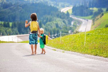 Küçük çocuklar, sırt çantaları olan erkek kardeşler, yolda seyahat
