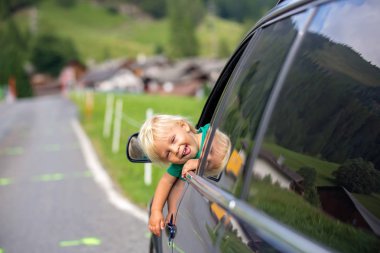 Sevimli çocuk, çocuk bir araba penceresinden bakarak, yolda seyahat