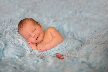 Şal içinde mutlu gülümseyen yeni doğan bebek mutlu cozy kürk uyku