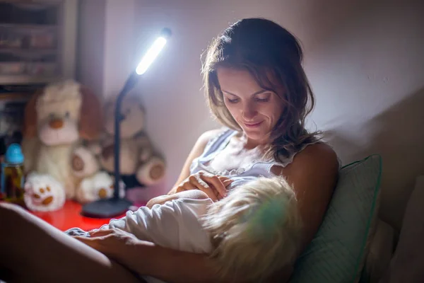 Mamma, amning hennes småbarn pojke hemma på natten, Night St — Stockfoto