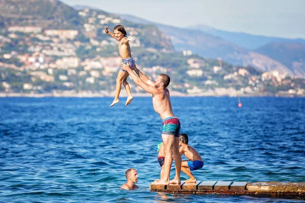 Ευτυχισμένη ομάδα ανθρώπων, παιδιά και ενήλικες, πηδώντας στο νερό — Φωτογραφία Αρχείου