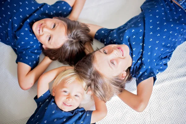 Діти, брати-сестри, лежать на підлозі на білій ковдрі , — стокове фото