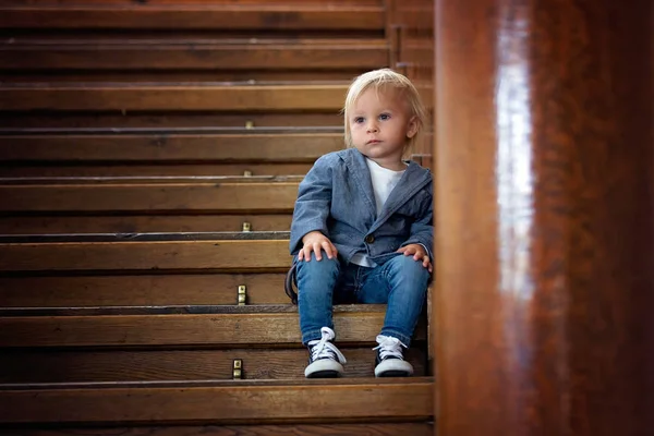 Triest kind, zittend op een trap in een groot huis, concept voor Bu — Stockfoto