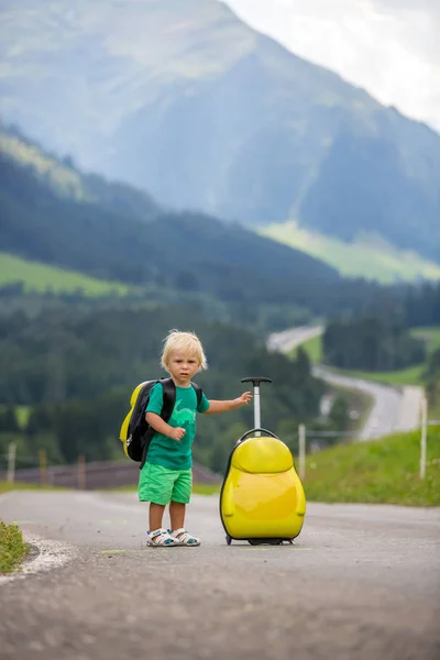 Bambino piccolo, ragazzo con zaini e valigia, viaggia sulla roa — Foto Stock