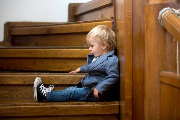 Sad child, sitting on a staircase in a big house, concept for bu — Stock Photo, Image