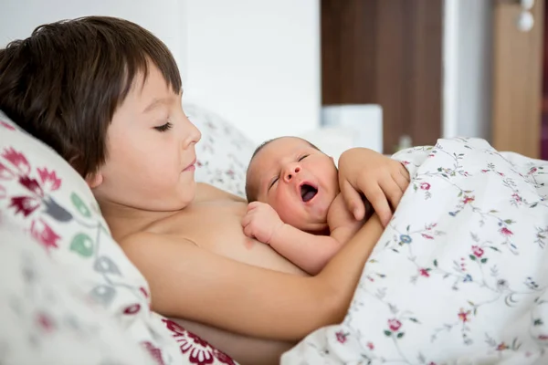 Krásný kluk, objímání s něhou a péči svého novorozeného dítěte — Stock fotografie