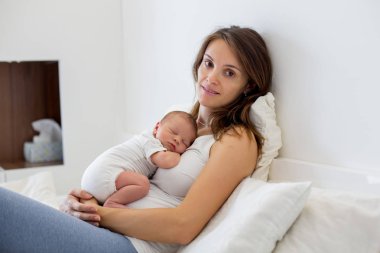 Genç anne onun yeni doğan bebek çocuk ile yatakta yalan