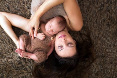 Güzel hassasiyet ile kucaklayan anne ve onun yeni doğan Bakımı 