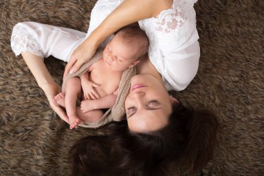 Güzel hassasiyet ile kucaklayan anne ve onun yeni doğan Bakımı 