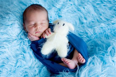 Şirin bebek çocuk, huzur içinde uyuyor mavi film içinde sarılmış