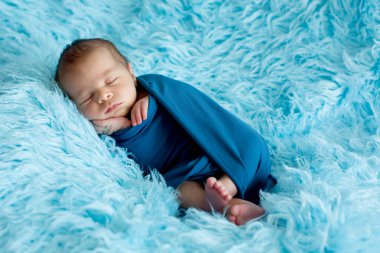 Şirin bebek çocuk, huzur içinde uyuyor mavi film içinde sarılmış