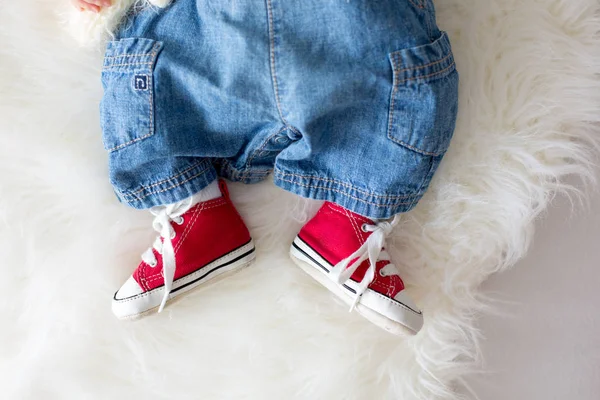 Μόδας κόκκινα πάνινα παπούτσια στα μικρά πόδια αγόρια νεογέννητο μωρό — Φωτογραφία Αρχείου