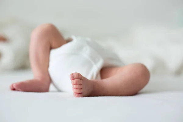 Pequeño niño pies, bebé se acuesta en la cama por la tarde — Foto de Stock