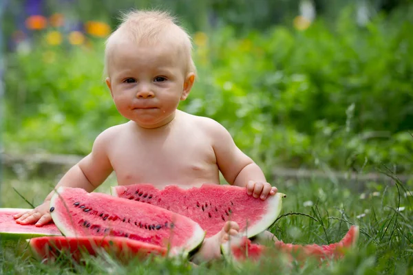 かわいい幼児の子供、男の子、庭で熟したスイカを食べる — ストック写真