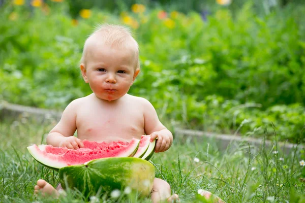 かわいい幼児の子供、男の子、庭で熟したスイカを食べる — ストック写真