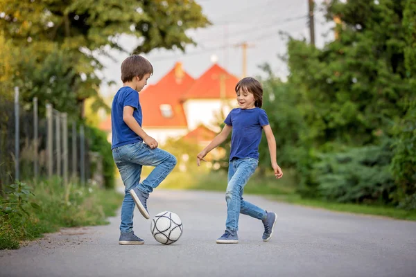 Dos lindos niños pequeños, jugando fútbol juntos, en verano. Chi. —  Fotos de Stock