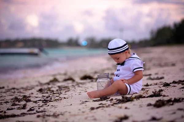 Piękny chłopiec malucha, ubrany jak marynarz, grając na plaży — Zdjęcie stockowe