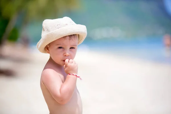 Zoete peuter jongen, spelen in ondiep water op een tropisch strand — Stockfoto