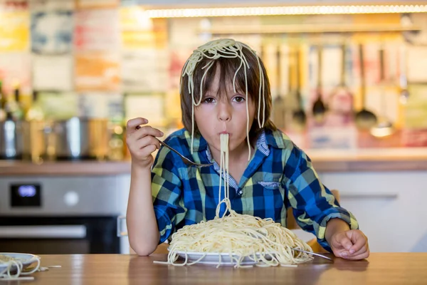 Little preschool boy, cute child, eating spaghetti for lunch and — Stock Photo, Image