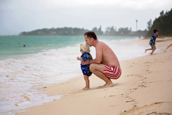 Padre e figlio, ragazzi, si divertono sulla spiaggia dell'oceano. Bambino eccitato — Foto Stock
