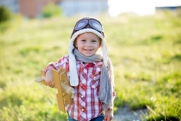 Süßes Kleinkind Baby Junge, Kind spielt mit Flugzeug in Mohn fie — Stockfoto