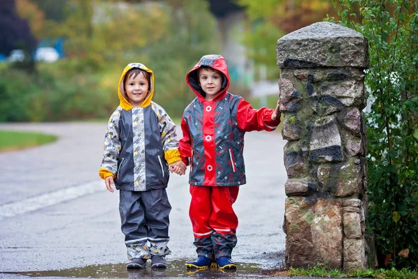 Dulces niños, niños, jugando en el parque en un día lluvioso —  Fotos de Stock