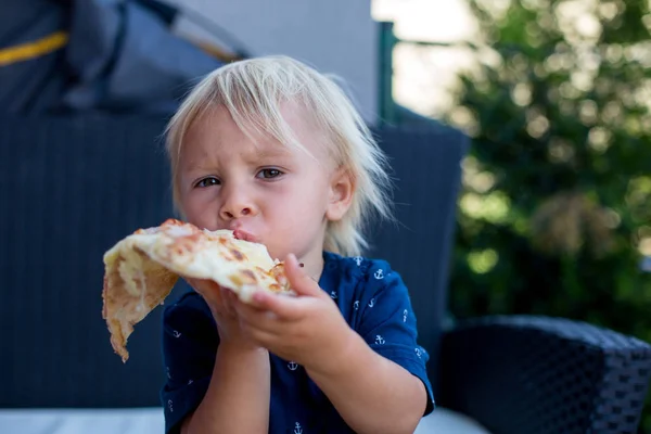 Ένα χαριτωμένο μικρό καυκάσιο παιδί που τρώει πίτσα. Πεινασμένο παιδί που παίρνει ένα bi — Φωτογραφία Αρχείου