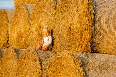 Mutlu çocuklar, yaz aylarında samanlıkta oynuyorlar.