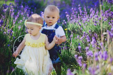 Mutlu gülümseyen bebek ikizler, erkek ve kız, vintage sandalyede oturan