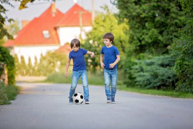 Birlikte futbol oynayan iki sevimli küçük çocuk, yaz. Chi