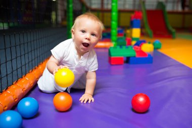 Küçük yürümeye başlayan çocuk, çocukların oyun alanında kapalı oynuyor