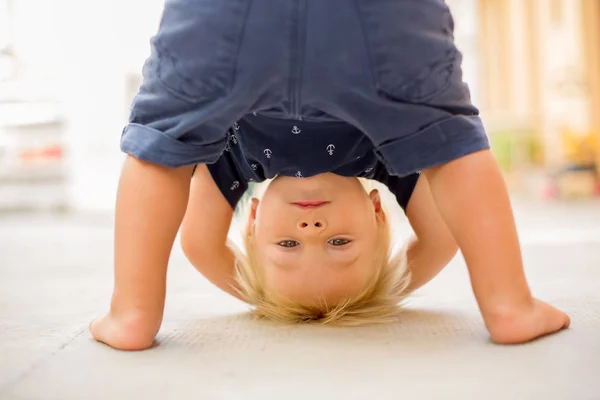 Child standing upside down, smiling happily — Stock Photo, Image